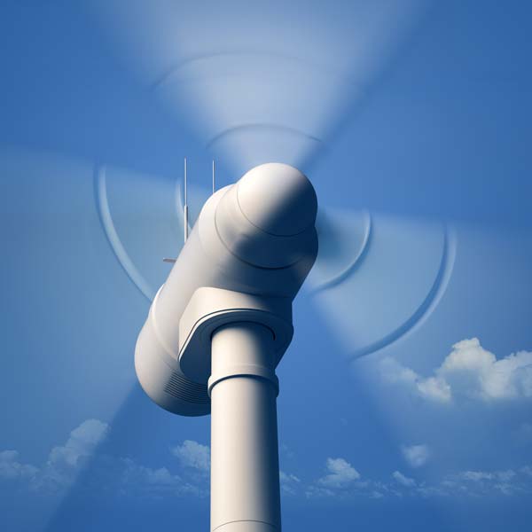 A wind turbine with rotating blades against a clear blue sky, showcasing renewable energy technology.
