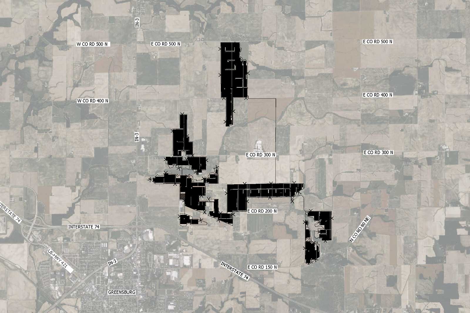 A satellite map showing rural areas with road names. Dark patches represent specific land plots amidst fields and roads.