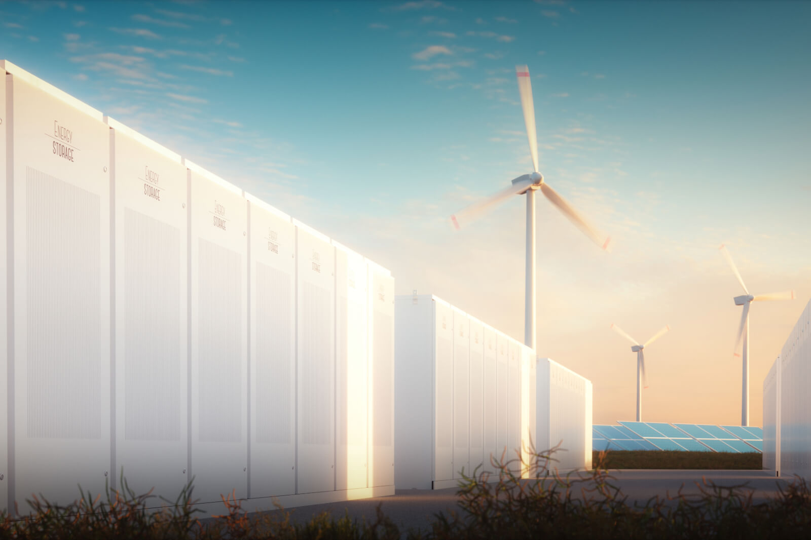 A renewable energy facility featuring white energy storage units, wind turbines, and solar panels under a clear sky.