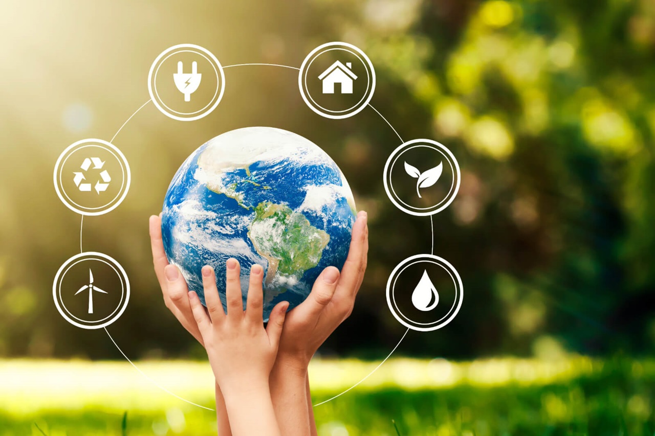 Hands holding the Earth with icons symbolising sustainability, energy, home, recycling, and water in a natural setting.